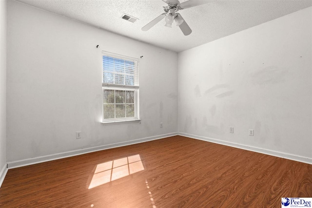 empty room featuring ceiling fan, hardwood / wood-style floors, and a textured ceiling