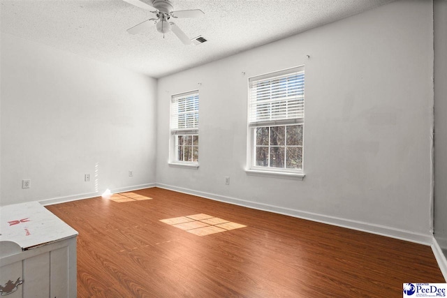 unfurnished room featuring wood-type flooring, ceiling fan, and a textured ceiling