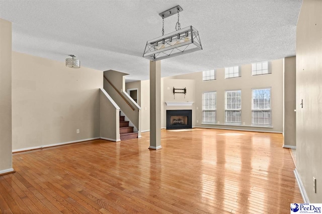 unfurnished living room featuring light hardwood / wood-style floors and a textured ceiling