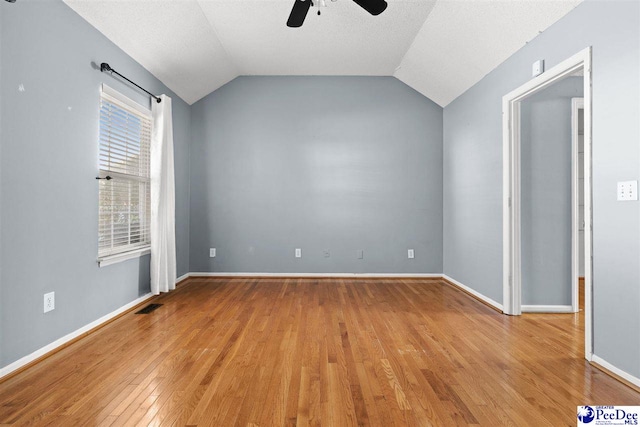 interior space featuring vaulted ceiling, a textured ceiling, ceiling fan, and light wood-type flooring