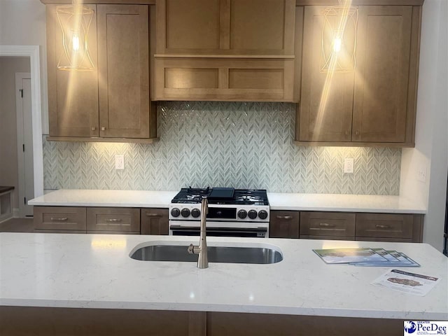 kitchen featuring light stone counters, gas stove, and backsplash