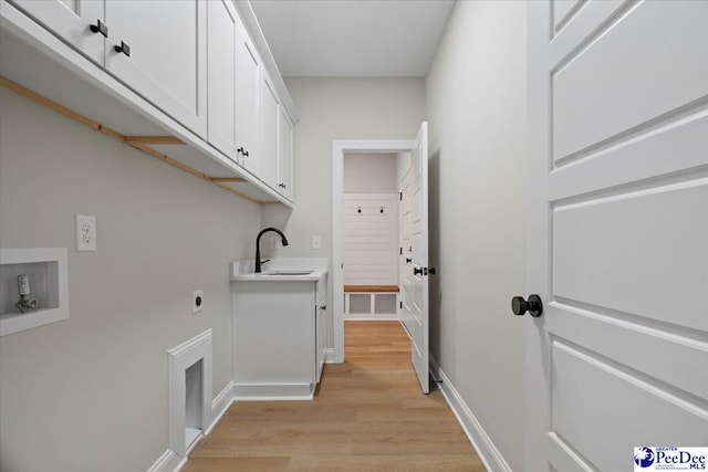 washroom featuring cabinet space, hookup for a washing machine, hookup for an electric dryer, light wood-type flooring, and a sink