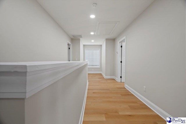 hallway with attic access, visible vents, baseboards, light wood-type flooring, and recessed lighting