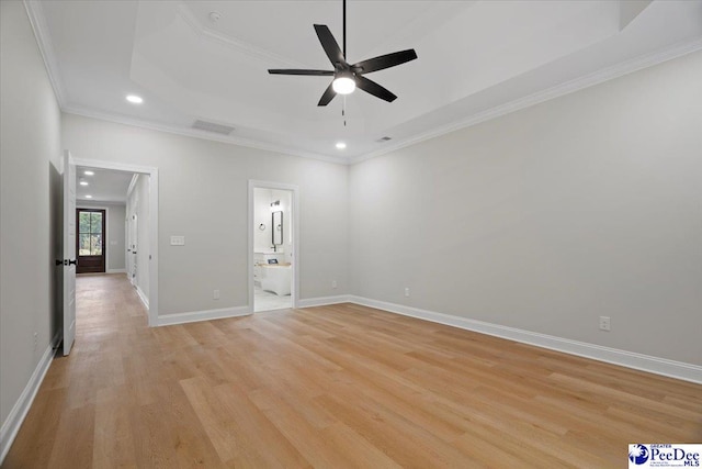 unfurnished room featuring a tray ceiling, recessed lighting, visible vents, light wood-style flooring, and baseboards