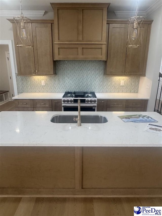 kitchen with hanging light fixtures, light stone counters, high end range, and crown molding