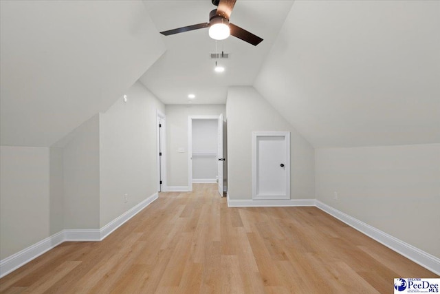 bonus room with light wood finished floors, baseboards, and vaulted ceiling