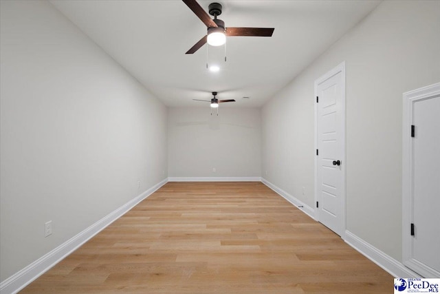 empty room with a ceiling fan, light wood-style flooring, and baseboards