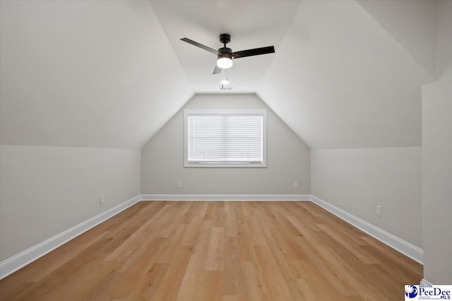 additional living space with light wood-style floors, lofted ceiling, baseboards, and a ceiling fan