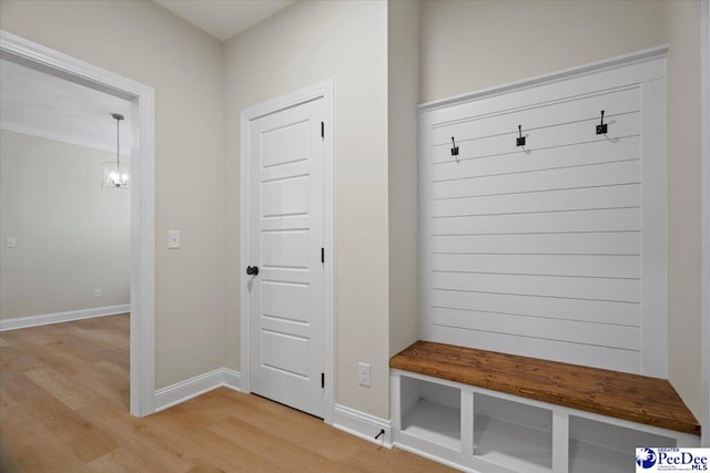 mudroom featuring light wood-style floors, a notable chandelier, and baseboards