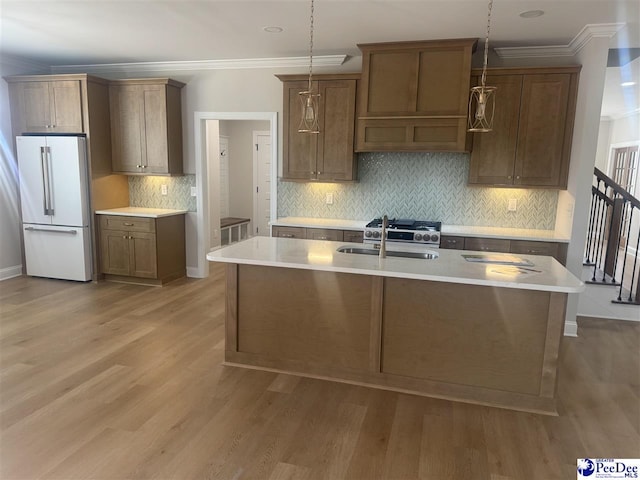 kitchen with light countertops, light wood finished floors, a sink, and freestanding refrigerator