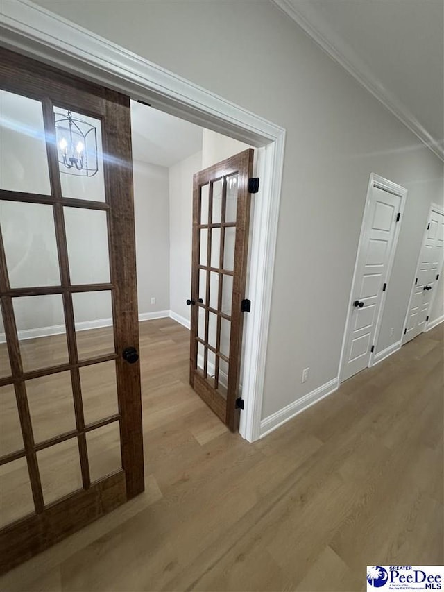 interior space with baseboards, wood finished floors, and french doors