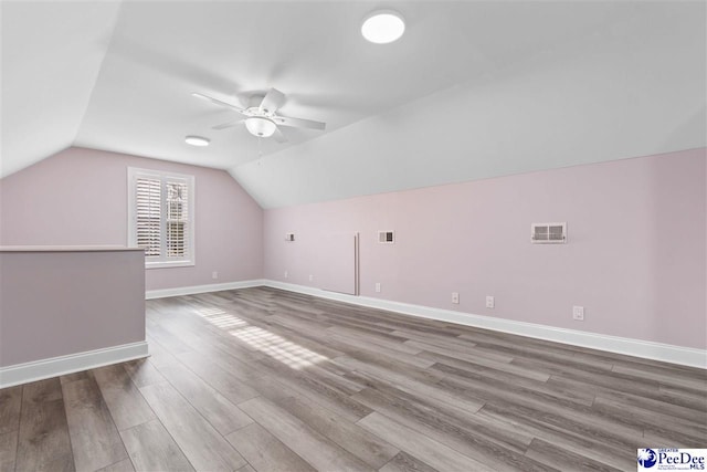 bonus room featuring visible vents, baseboards, vaulted ceiling, wood finished floors, and a ceiling fan