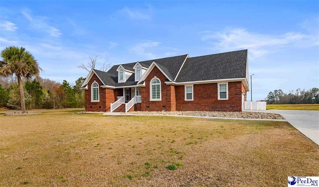 view of front of home with driveway, a front yard, a shingled roof, crawl space, and brick siding