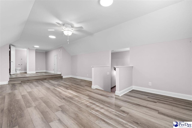 bonus room with baseboards, a ceiling fan, lofted ceiling, and wood finished floors