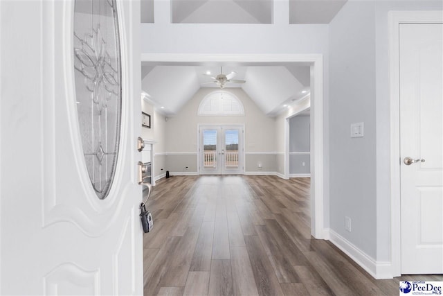 foyer entrance featuring a ceiling fan, wood finished floors, french doors, baseboards, and lofted ceiling