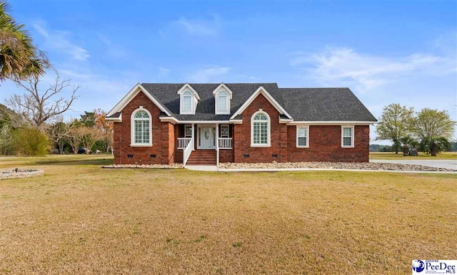 cape cod house with a shingled roof, a front yard, brick siding, and crawl space