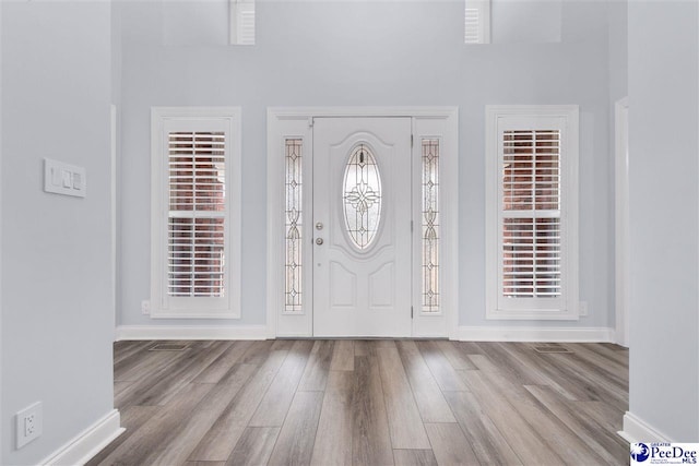 foyer featuring baseboards and wood finished floors