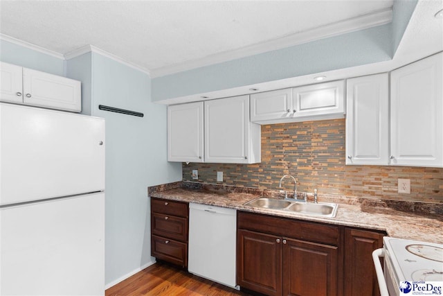 kitchen with tasteful backsplash, white appliances, crown molding, and a sink