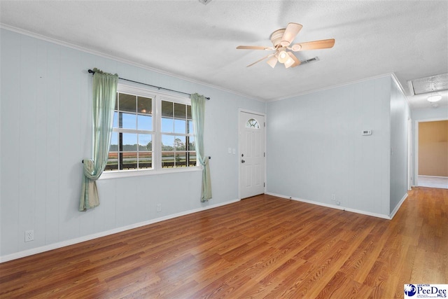 spare room with crown molding, ceiling fan, and wood finished floors