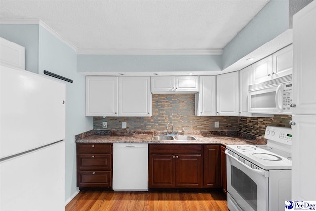 kitchen with ornamental molding, a sink, backsplash, and white appliances