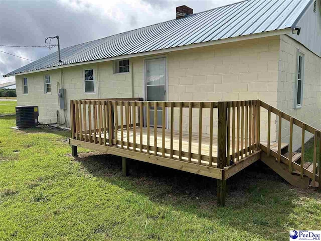 565 Davids Pond Rd, Bennettsville, SC 29512 - rear view of house featuring concrete block siding, a chimney, central AC unit, a yard, and metal roof