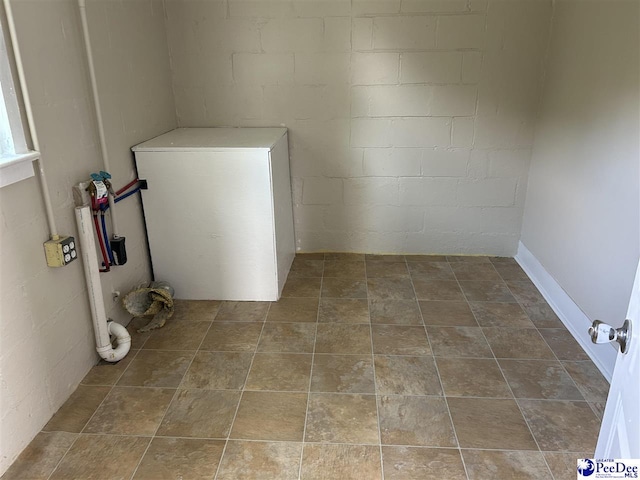 565 Davids Pond Rd, Bennettsville, SC 29512 - clothes washing area featuring concrete block wall and stone finish floors