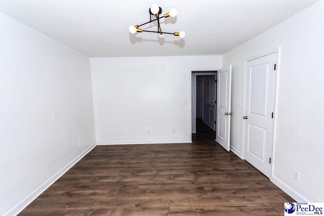 2318 Heron Dr, Florence, SC 29501 - unfurnished dining area featuring dark wood-type flooring, a textured ceiling, and a notable chandelier