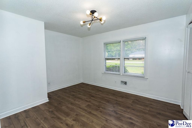 2318 Heron Dr, Florence, SC 29501 - spare room with dark wood-type flooring, an inviting chandelier, and a textured ceiling