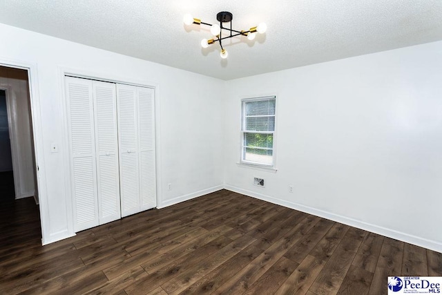 2318 Heron Dr, Florence, SC 29501 - unfurnished bedroom with a chandelier, a textured ceiling, dark hardwood / wood-style flooring, and a closet
