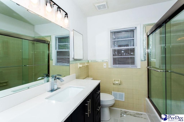 2318 Heron Dr, Florence, SC 29501 - full bathroom featuring enclosed tub / shower combo, tile walls, radiator heating unit, vanity, and toilet