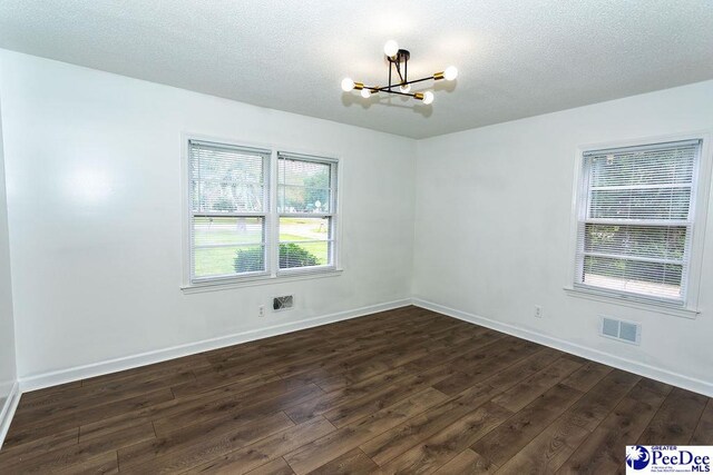 2318 Heron Dr, Florence, SC 29501 - unfurnished room with an inviting chandelier, dark hardwood / wood-style floors, and a textured ceiling
