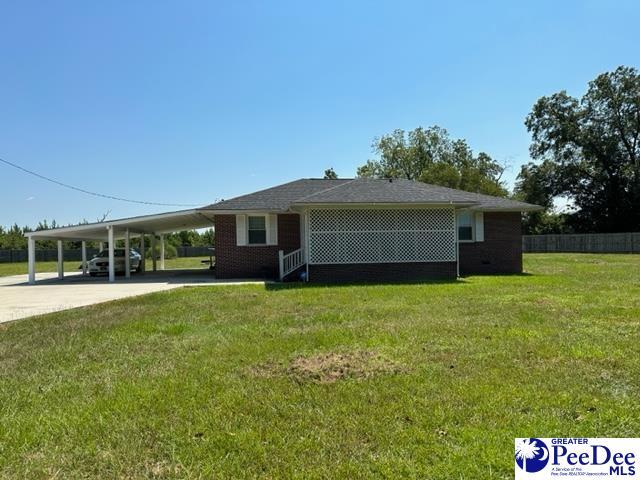 view of front of property with a front yard and a carport