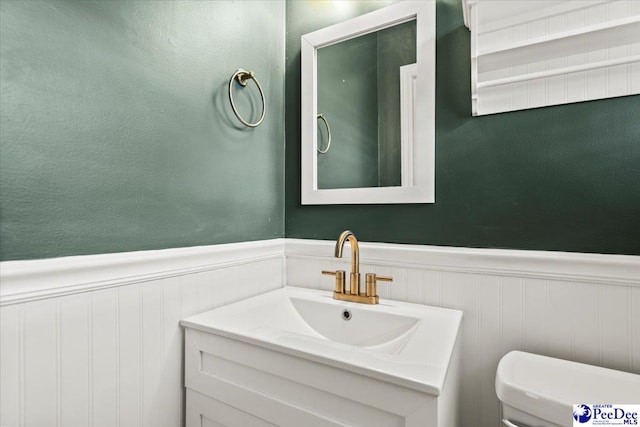 160 Central Dr, Florence, SC 29501 - half bath with wainscoting, toilet, vanity, and a decorative wall