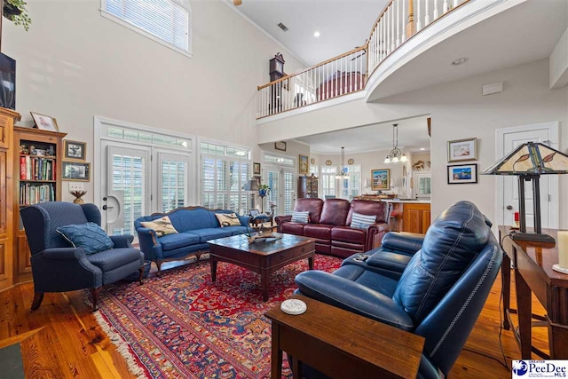 living room with hardwood / wood-style flooring, a notable chandelier, and a wealth of natural light