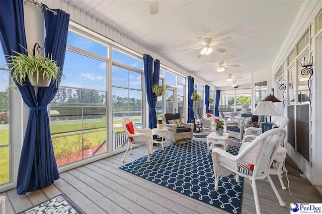 sunroom with a water view and ceiling fan