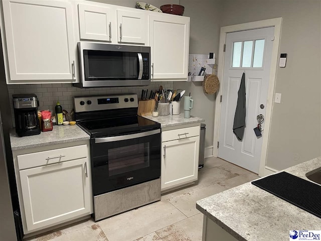 kitchen featuring tasteful backsplash, appliances with stainless steel finishes, and white cabinets