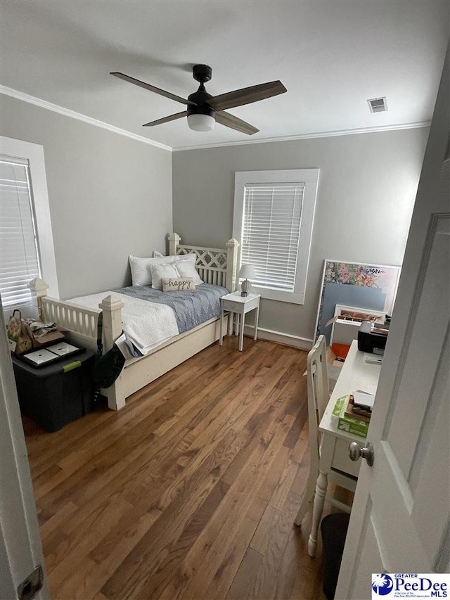 bedroom featuring ceiling fan, ornamental molding, and dark hardwood / wood-style floors