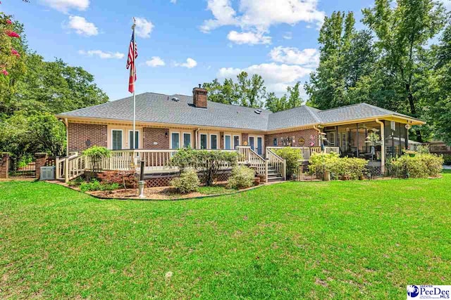 4105 Byrnes Blvd, Florence, SC 29506 - back of property featuring a sunroom, a chimney, a wooden deck, and a yard
