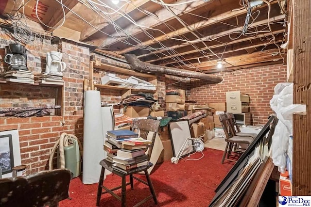 basement featuring brick wall and carpet floors