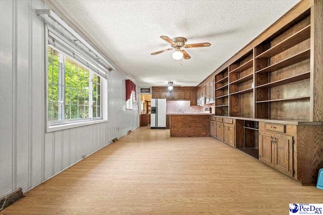 kitchen featuring ceiling fan, light hardwood / wood-style floors, white fridge with ice dispenser, and a textured ceiling