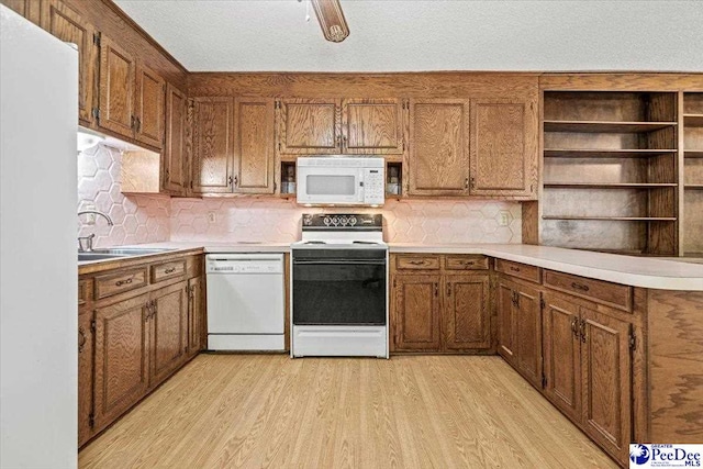 kitchen with sink, light hardwood / wood-style flooring, a textured ceiling, white appliances, and backsplash