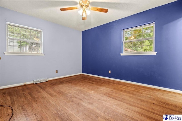 unfurnished room featuring wood-type flooring, ceiling fan, and a textured ceiling