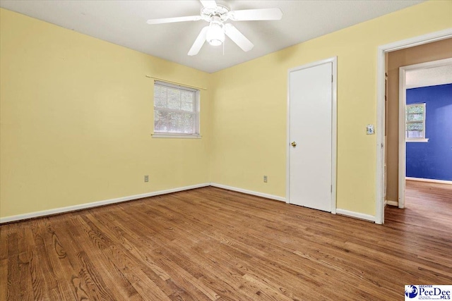 unfurnished room with hardwood / wood-style floors and ceiling fan