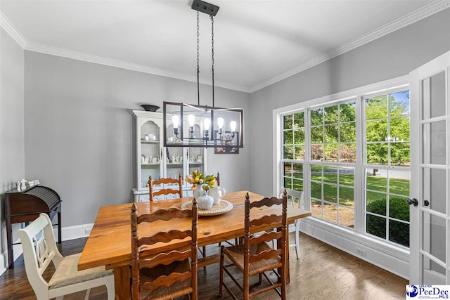 2409 Sarazen Ct, Florence, SC 29506 - dining area with crown molding, wood finished floors, a chandelier, and baseboards