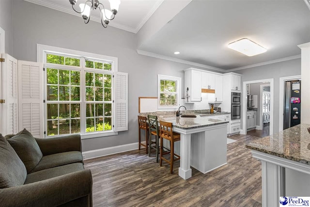 2409 Sarazen Ct, Florence, SC 29506 - kitchen with a sink, a chandelier, dark wood finished floors, a peninsula, and white cabinets