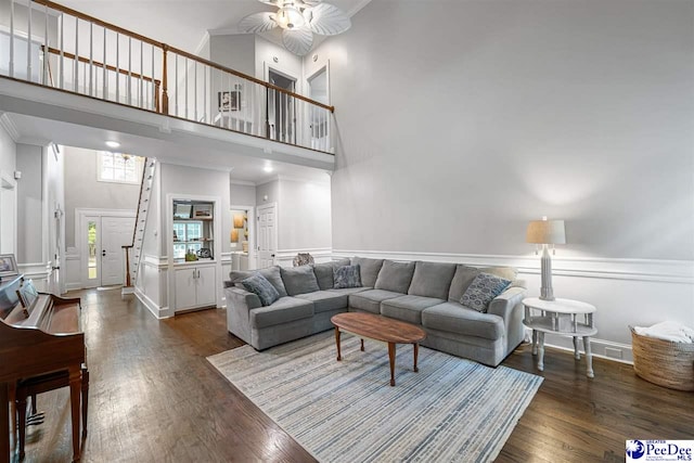 2409 Sarazen Ct, Florence, SC 29506 - living room featuring a high ceiling, a ceiling fan, wood finished floors, a wainscoted wall, and ornamental molding