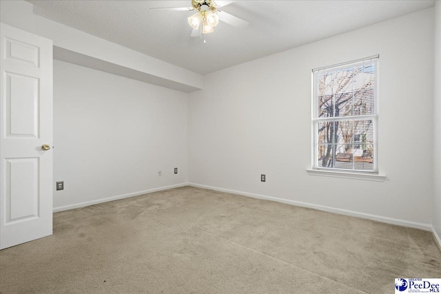 interior space with ceiling fan, baseboards, a textured ceiling, and light colored carpet