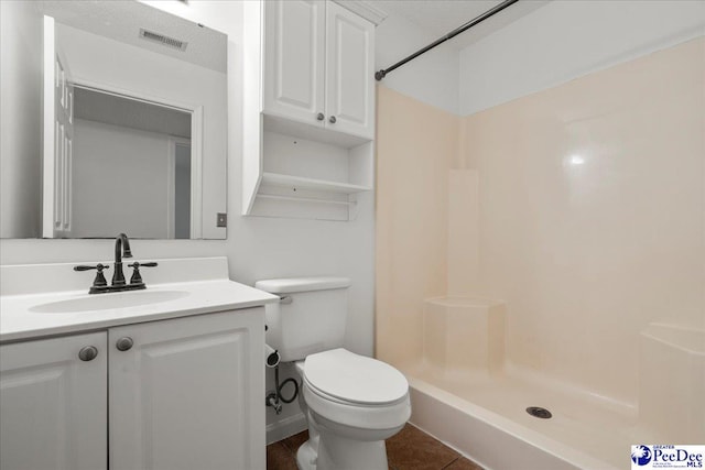 full bath featuring a textured ceiling, toilet, visible vents, vanity, and a shower stall