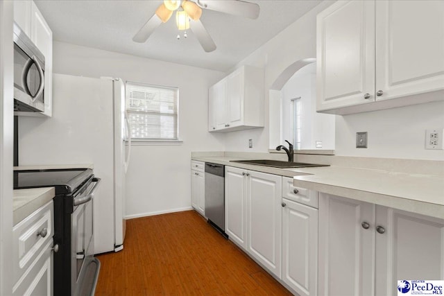 kitchen featuring light countertops, appliances with stainless steel finishes, a wealth of natural light, and white cabinets