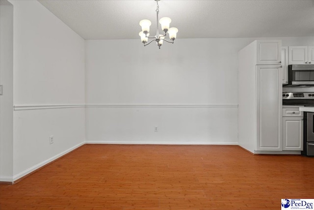 unfurnished dining area with light wood-type flooring, baseboards, and a chandelier